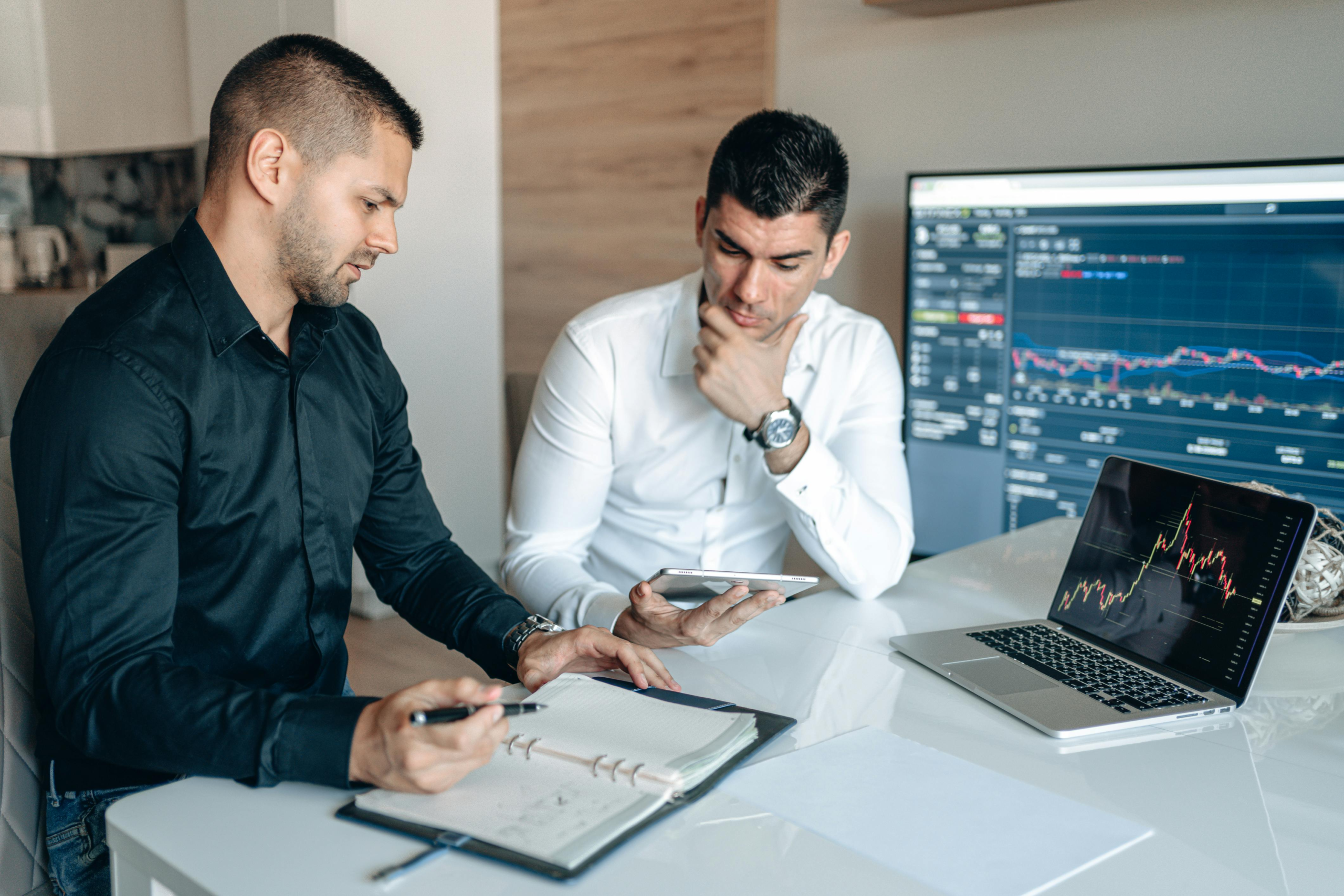 two business professionals reviewing documents together at desk during a staffing or hiring discussion